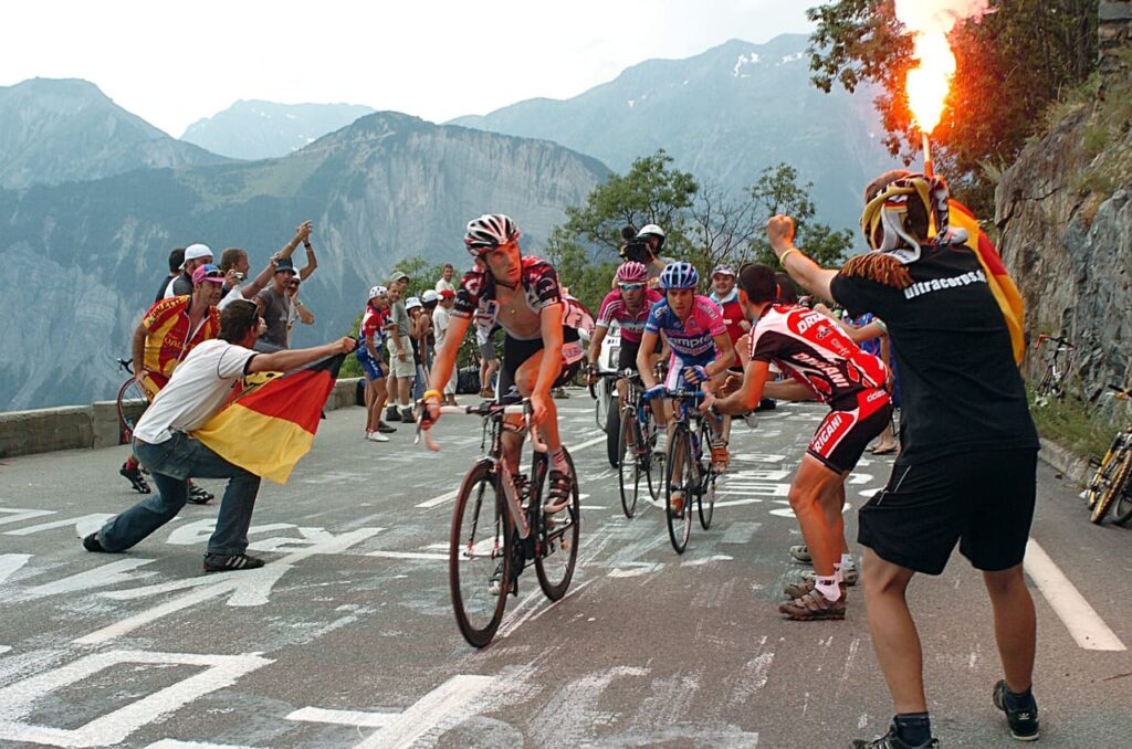 Ciclistas disputando o Tour de France e torcedores celebrando